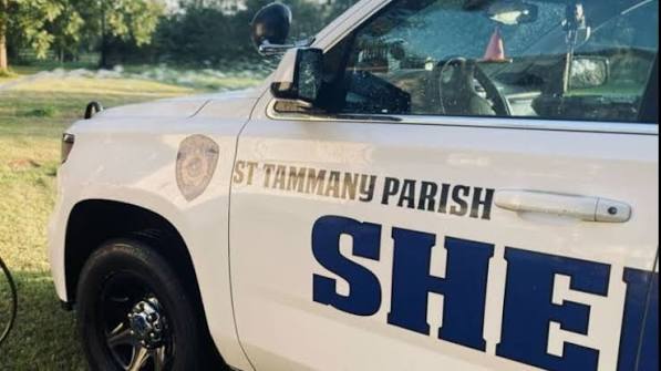 STPSO White sheriff's patrol SUV with 'St. Tammany Parish Sheriff' lettering on the side, parked on grass.